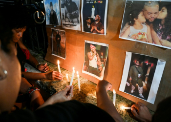 Cuban fans light candles next to pictures of the late singer, Jose Manuel Carbajal Zaldivar, known as 'El Taiger,' as they pay tribute in Havana. ©AFP