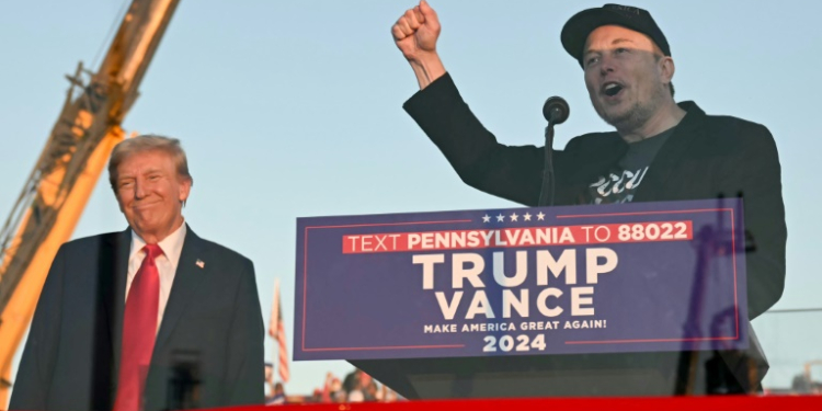 Tesla CEO Elon Musk (R) speaks on stage as he joins former US President and Republican presidential candidate Donald Trump during a campaign rally . ©AFP