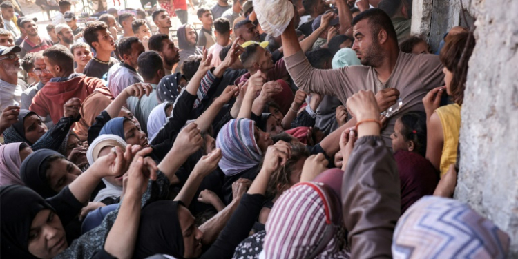 People clamour for bread outside a bakery in the city of Khan Yunis in aid-starved Gaza. ©AFP