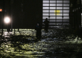 People take photos and videos as they walk through streets inundated by floodwaters after Hurricane Milton made landfall in Fort Myers / ©AFP