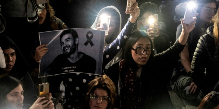 Fans light cellphones as they pay tribute to the late British singer Liam Payne at the Revolucion monument in Mexico City on October 17, 2024. ©AFP