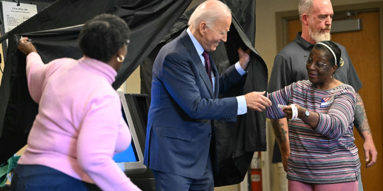 US President Joe Biden is handed an 'I Voted' sticker as he steps out of the booth after casting his ballot early in Delaware  / ©AFP