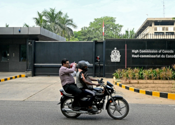 A motorist rides past the entrance of the Canadian High Commission in New Delhi as tensions between the countries escalates / ©AFP