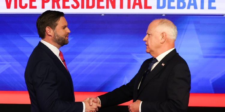 US Senator and Republican vice presidential candidate J.D. Vance (L) and Minnesota Governor and Democratic vice presidential candidate Tim Walz shake hands at the start of the Vice Presidential debate / ©AFP