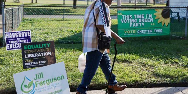 Chester Todd walks past campaign signs outside his home in Racine, Wisconsin, where he's running for the House of Representatives in the state's first district / ©AFP