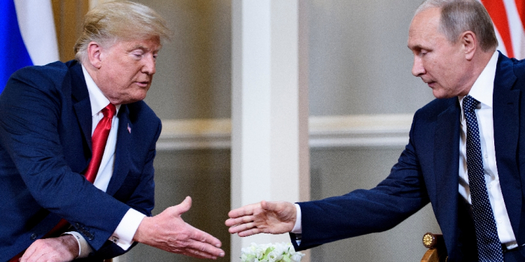 Then US president Donald Trump and Russian President Vladimir Putin reach to shake hands before a meeting in Helsinki on July 16, 2018 / ©AFP