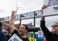 Striking workers at the Red Hook Container Terminal in Brooklyn, New York, gather after members of the International Longshoremen's Association began walking off the job / ©AFP