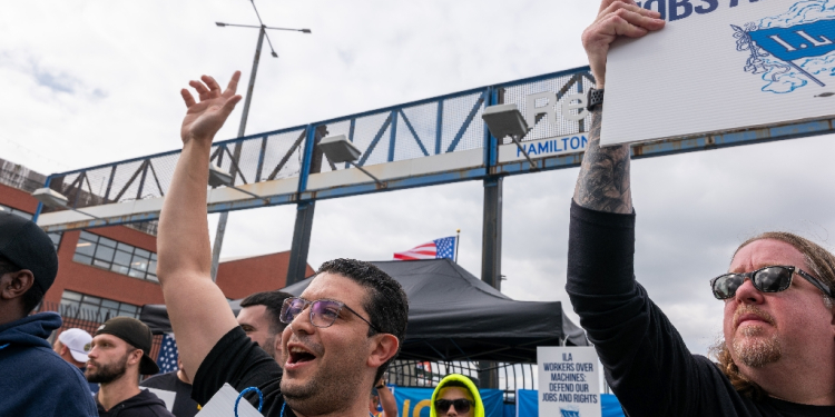 Striking workers at the Red Hook Container Terminal in Brooklyn, New York, gather after members of the International Longshoremen's Association began walking off the job / ©AFP