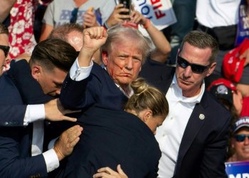 Republican presidential candidate Donald Trump ducked down as Secret Service agents flooded the stage during an assassination attempt in July. ©AFP