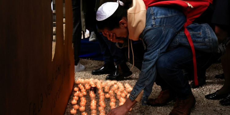 A mourner in Nice, France, lays down a candle at a ceremony in tribute of the victims of October 7 attack. ©AFP