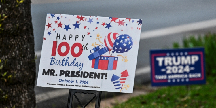 As crowds gathered for Carter's 100th birthday this week, observers could see what might seem like a contradiction anywhere else: signs celebrating Carter in the same yard as placards for Trump's presidential campaign / ©AFP