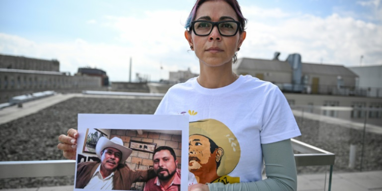 Brenda Diaz Valencia is seen in Washington holding a photo of her father, Antonio Diaz Valencia, and his colleague Ricardo Lagunes, both of whom disappeared after criticizing mining practices in Mexico. ©AFP