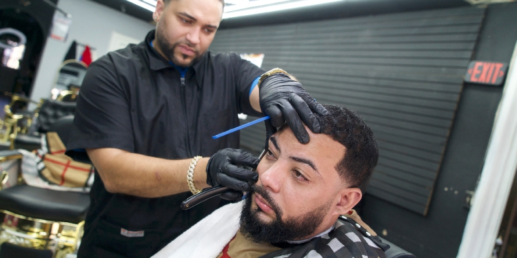 Kenny Ramirez, a Dominican-American barber who voted for Donald Trump in the US presidential election, trims hair at his barbershop in Reading, Pennsylvania on November 13, 2024 / ©AFP