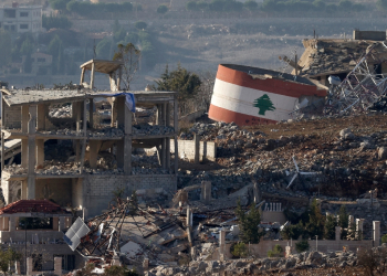 An Israeli flag hangs on a destroyed building while a Lebanese flag is painted on another in the southern Lebanese village of Meiss El-Jabal / ©AFP