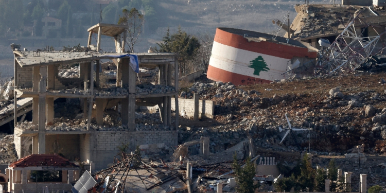 An Israeli flag hangs on a destroyed building while a Lebanese flag is painted on another in the southern Lebanese village of Meiss El-Jabal / ©AFP