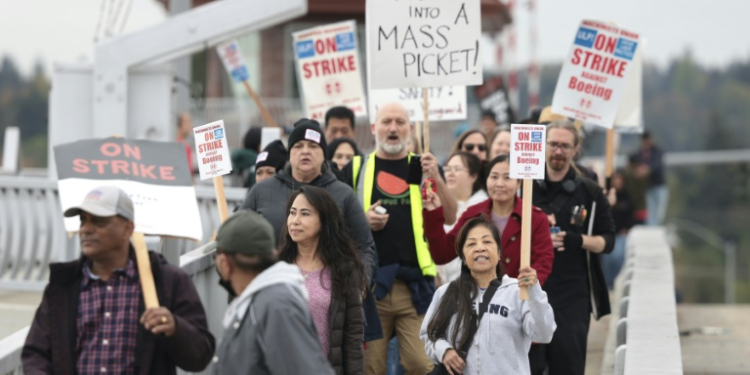 Striking workers with the International Association of Machinists and Aerospace Workers will weigh Boeing's latest offer after voting down two previous contracts . ©AFP