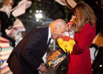 Joe Biden jokingly bit a baby dressed as a chicken as he hosted a Halloween trick-or-treat event at the White House / ©AFP