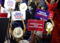 People hold signs that read American Oil from American Soil at a Trump rally  / ©AFP