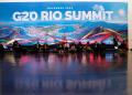 People sit and work next to a giant banner of the G20 Summit in Rio de Janeiro, Brazil, on November 18, 2024. ©AFP