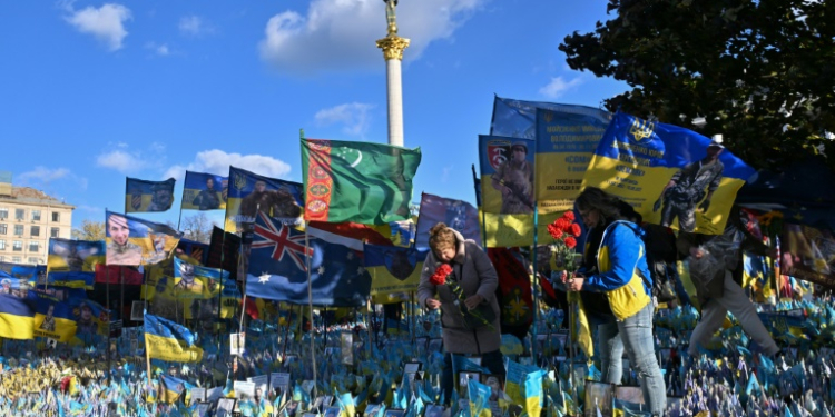 Women lay flowers in tribute to fallen Ukrainian soldiers at a makeshift memorial in Kyiv. ©AFP