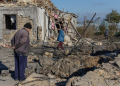 A local resident inspects a crater in the courtyard of a destroyed building following a missile attack at an undisclosed location in Odesa region on November 17. ©AFP