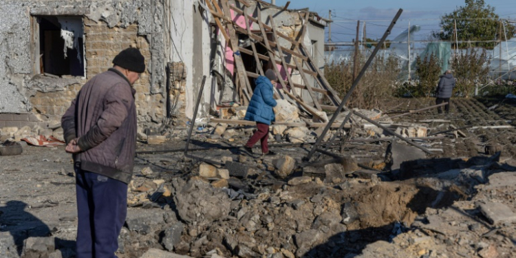 A local resident inspects a crater in the courtyard of a destroyed building following a missile attack at an undisclosed location in Odesa region on November 17. ©AFP