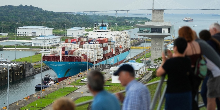 Tourists watch a Danish-flagged cargo ship passing through the Panama Canal / ©AFP