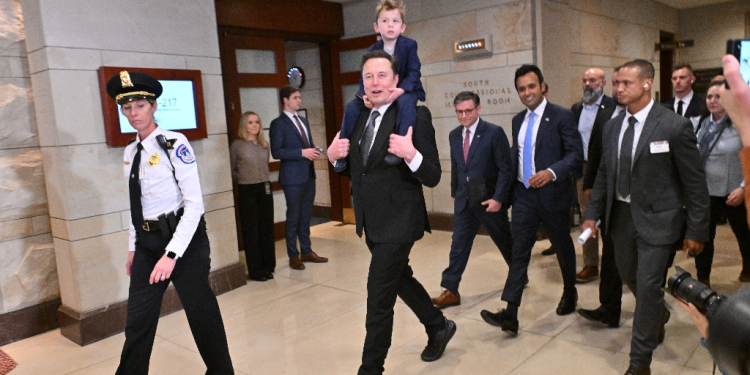 Elon Musk, with his son on his shoulders, and entrepreneur Vivek Ramaswamy met members of Congress to discuss their plans for slashing government spending under Donald Trump / ©AFP