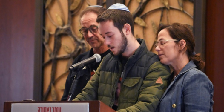 At a Jewish community center in Syosset, New York, Daniel Neutra, with his parents Ronen and Orna, speaks at a memorial ceremony for his brother Omer, who died in the October 7 Hamas attack on Israel . ©AFP