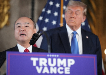 SoftBank CEO Masayoshi Son delivers remarks while US President-elect Donald Trump looks on at Mar-a-Lago in Florida on December 16, 2024 / ©AFP