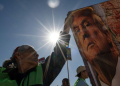 A demonstrator at a Mexico-US border crossing in Tijuana holds a banner with the image of US President-elect Donald Trump, who has vowed a mass deportation of undocumented immigrants . ©AFP