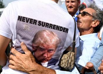 A woman wears a tee-shirt depicting the mug shot of President-elect Donald Trump in Pontida, northern Italy, on September 17, 2023 / ©AFP