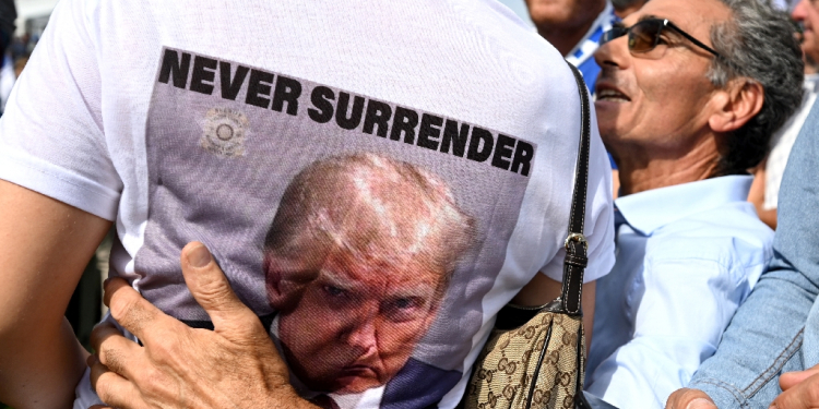 A woman wears a tee-shirt depicting the mug shot of President-elect Donald Trump in Pontida, northern Italy, on September 17, 2023 / ©AFP