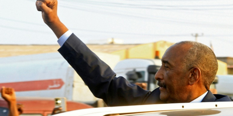 Sudan's army chief Abdel Fattah al-Burhan gestures to people waiting to greet him along a street in Port Sudan on January 14, 2025. ©AFP