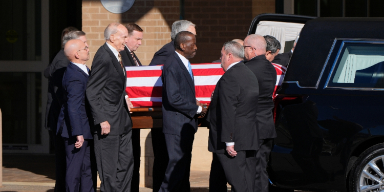 Former and current US Secret Service agents assigned to the Carter detail walk with the hearse carrying the flag-draped casket of former US President Jimmy Carter in Americus, Georgia, on January 4, 2025 / ©AFP