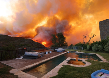 A brush fire burns near homes in upscale Pacific Palisades, California on January 7, 2025. ©AFP