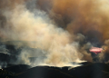 In this aerial view taken from a helicopter, an air tanker drops fire retardant on the Kenneth Fire in the Calabasas area of Los Angeles. ©AFP