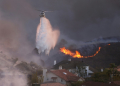 The upscale neighborhood of Pacific Palisades remains blanketed by a thick cloud of black smoke that blots out the sun. ©AFP