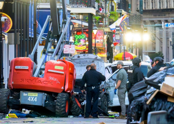 Police investigators surround the white Ford F-150 pickup truck that crashed into a work lift after allegedly driving into a crowd of New Year's revelers in the French Quarter of New Orleans, Louisiana, on January 1, 2025. ©AFP