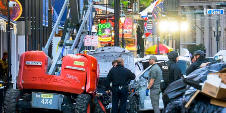 Police investigators surround the white Ford F-150 pickup truck that crashed into a work lift after allegedly driving into a crowd of New Year's revelers in the French Quarter of New Orleans, Louisiana, on January 1, 2025. ©AFP