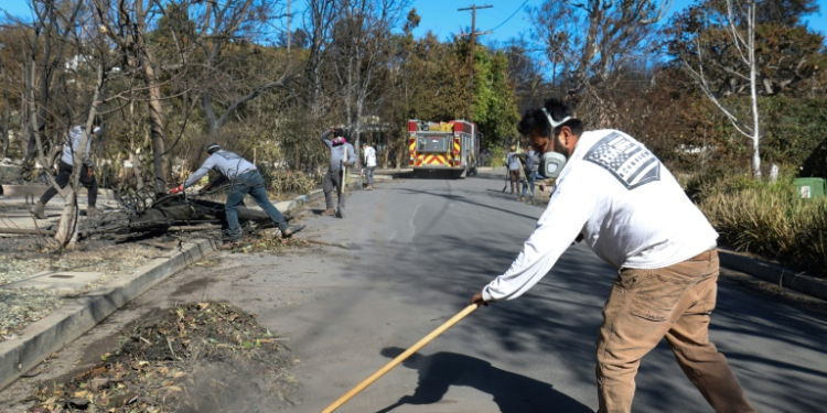 Chuck Hart's team of employees are not being paid or contracted by officials to do clean-up work, and are only focusing on public roads and sidewalks . ©AFP