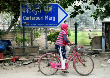 A cyclist rides past a sign pointing to Carterpuri, a village visited in 1978 by late US president Jimmy Carter. ©AFP