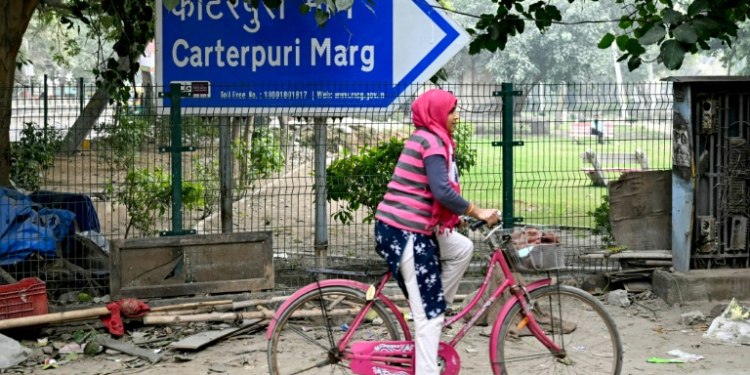 A cyclist rides past a sign pointing to Carterpuri, a village visited in 1978 by late US president Jimmy Carter. ©AFP