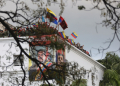 Members of the guard of honor of Venezuelan President Nicolas Maduro wave flags on the roof of the Miraflores presidential palace on January 23, 2025 / ©AFP