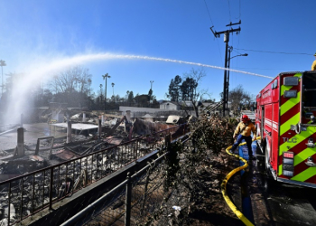 Firefighters water down smoky embers at the fire ravaged Sahag Mesrob Armenian Christian School in Altadena, California. ©AFP