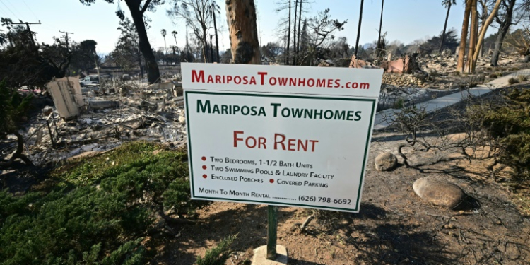 The remains of townhomes destroyed by the Eaton Fire lie behind an advertising sign in Altadena, California. ©AFP