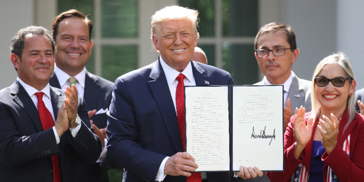 Donald Trump, shown in this July 2020 photo, holds up an executive order he signed during his first term as president  / ©AFP