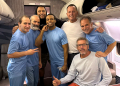 US President Donald Trump's envoy Richard Grenell (3rd R) poses onboard a plane alongside six Americans released from detention in Venezuela / ©AFP