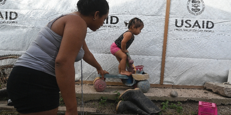 Sandra Ramos plays with her daughterat an improvised shack built with the help of the US Agency for the International Development (USAID) following hurricanes in in La Lima, Honduras, in July 2022 / ©AFP