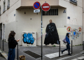 A pedestrian stands next to a graffiti created by French artist Big Ben street Art, depicting US Donald Trump as Darth Vader in Lyon, on November 6, 2024 / ©AFP